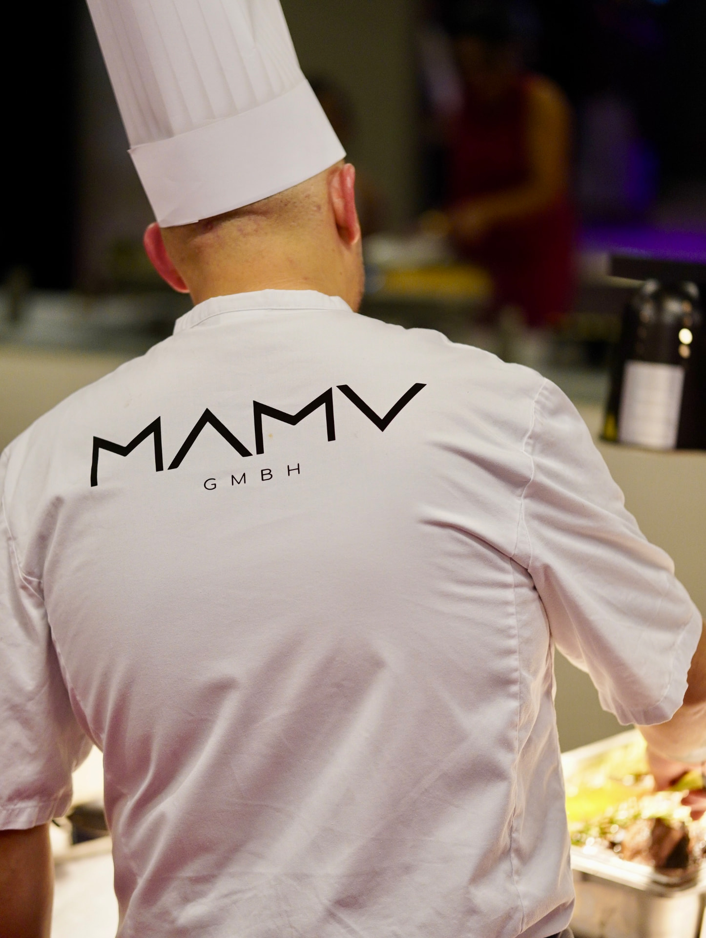 Küchenchef bei der Zubereitung und Ausgabe am Cateringbuffet