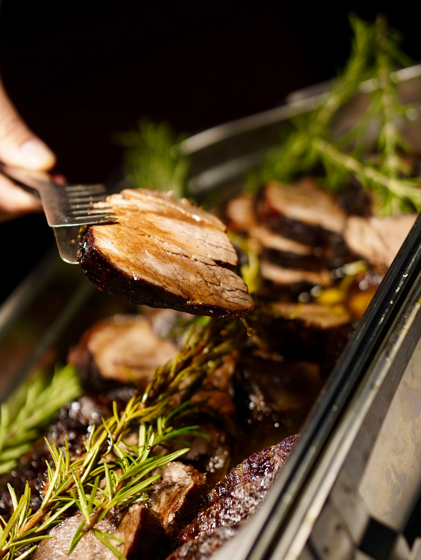 Frisch aufgeschnittenes Bratenstück mit Rosmarin am Buffet