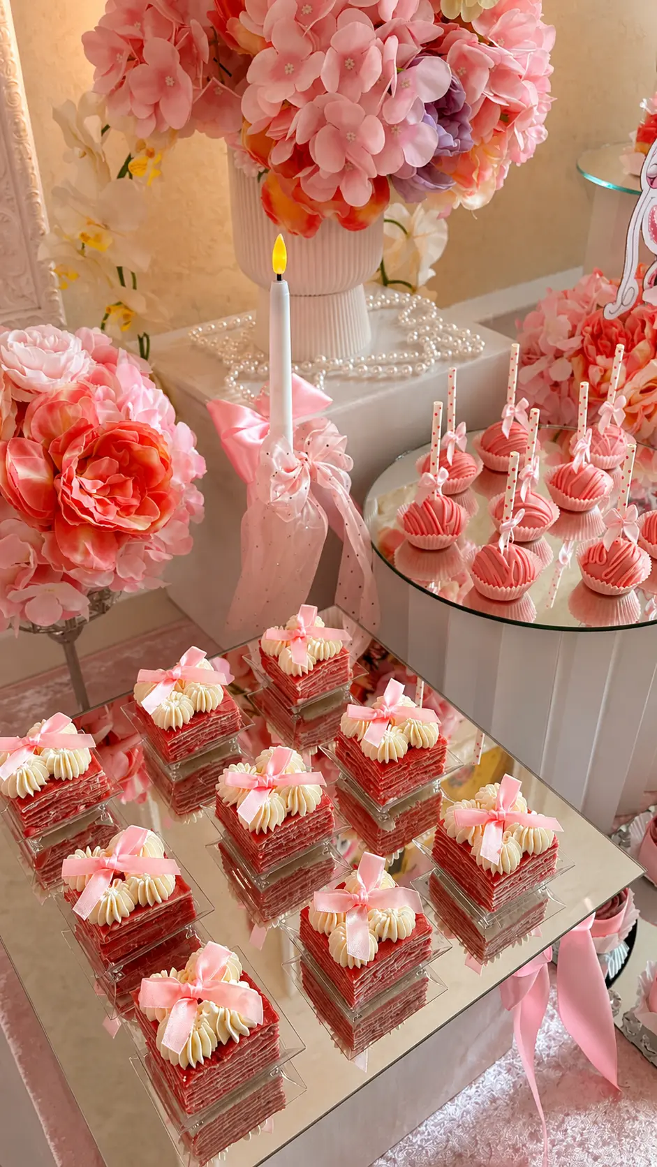 Rosa Desserttafel mit Satinschleifen, Red-Velvet-Schnitten, Cake-Pops und Blumenarrangements
