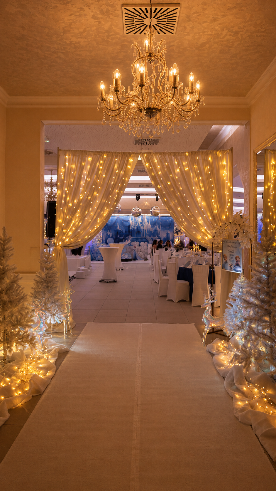 Winterliches Wunderland zum 18. Geburtstag mit goldenem Lichtervorhang, weißen Tannenbäumen, gläsernen Rentieren und blauer Hintergrundkulisse