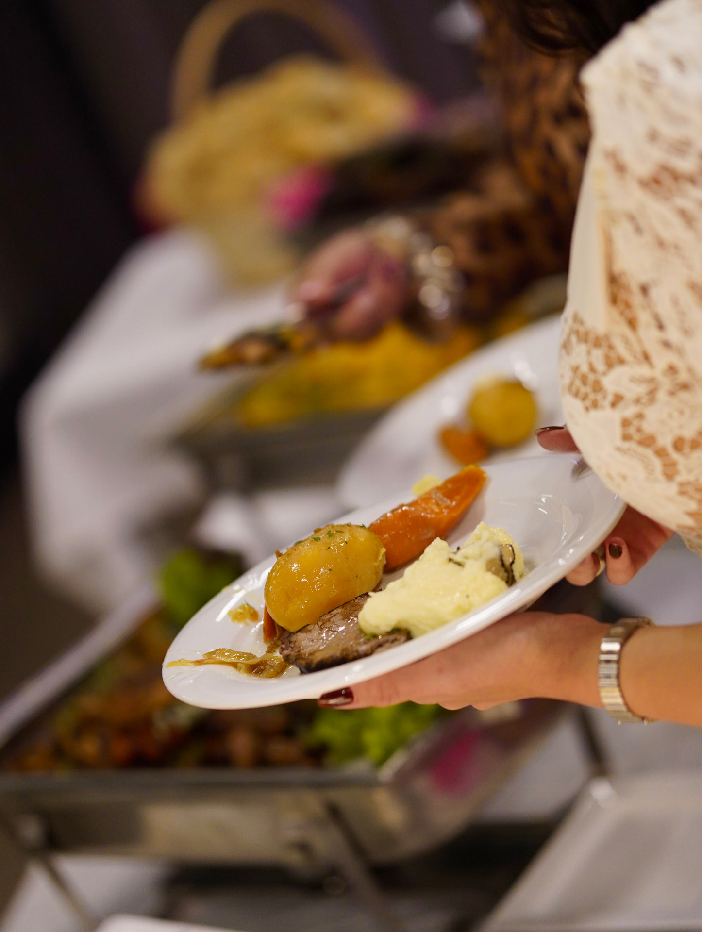 Gast mit frisch zusammengestelltem Teller am Buffet