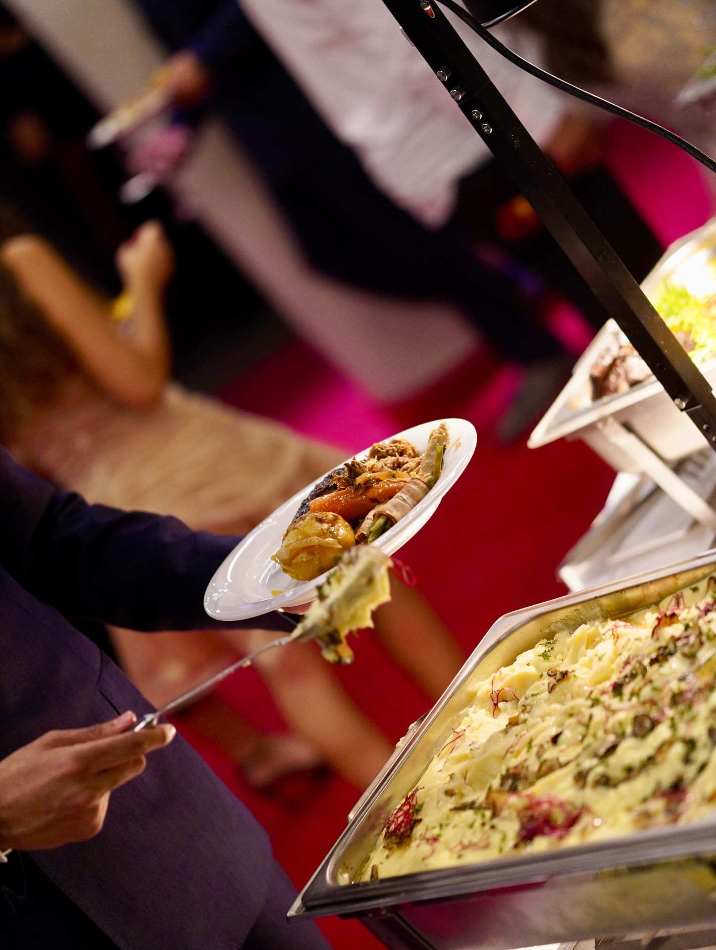 Gast schöpft eine cremige Beilage am festlichen Cateringbuffet