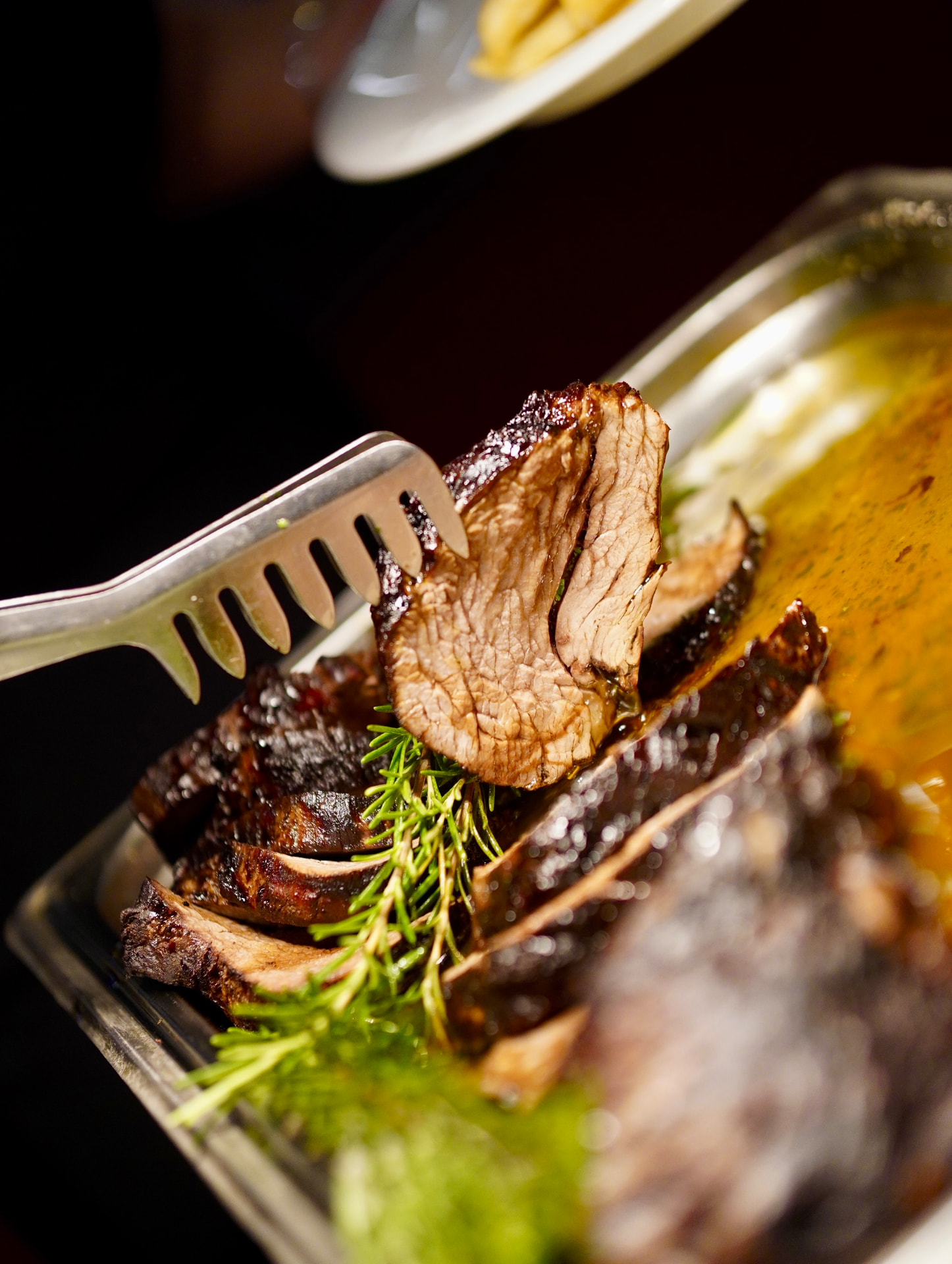 Saftige Scheibe Rinderbraten über Rosmarin und Bratensaft