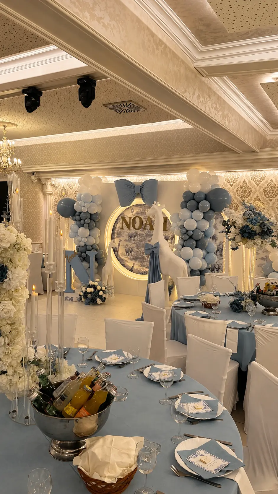 Babyfeier in Blau und Gold mit Safari-Rundwand, Ballongirlanden und blau gedeckten Tischen