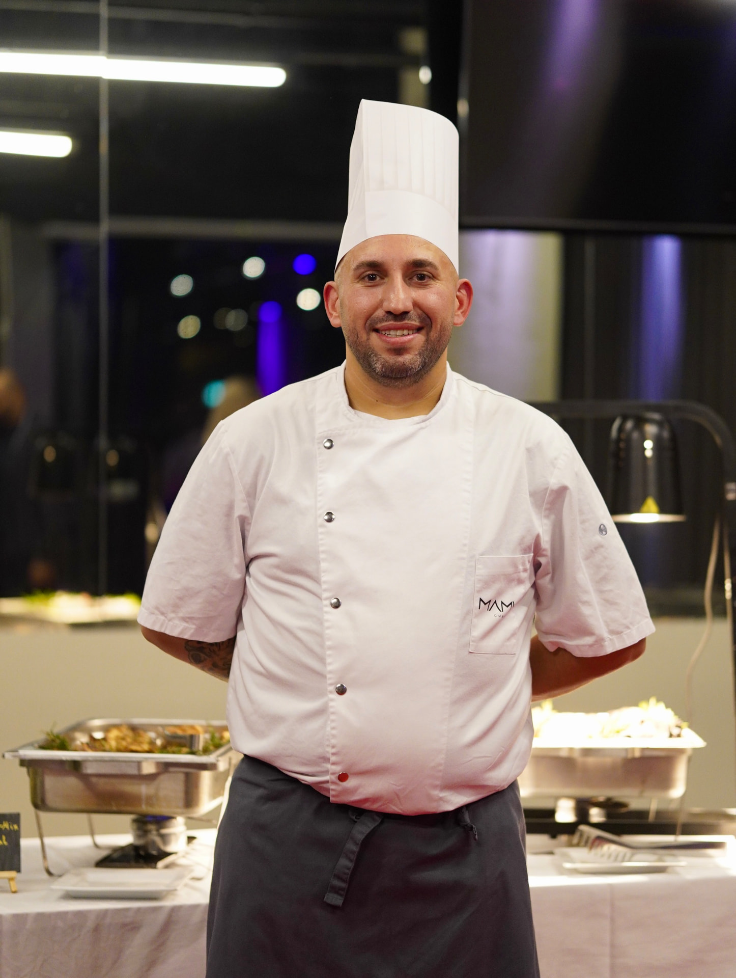 Küchenchef von Sallon 22 vor dem frisch vorbereiteten Cateringbuffet
