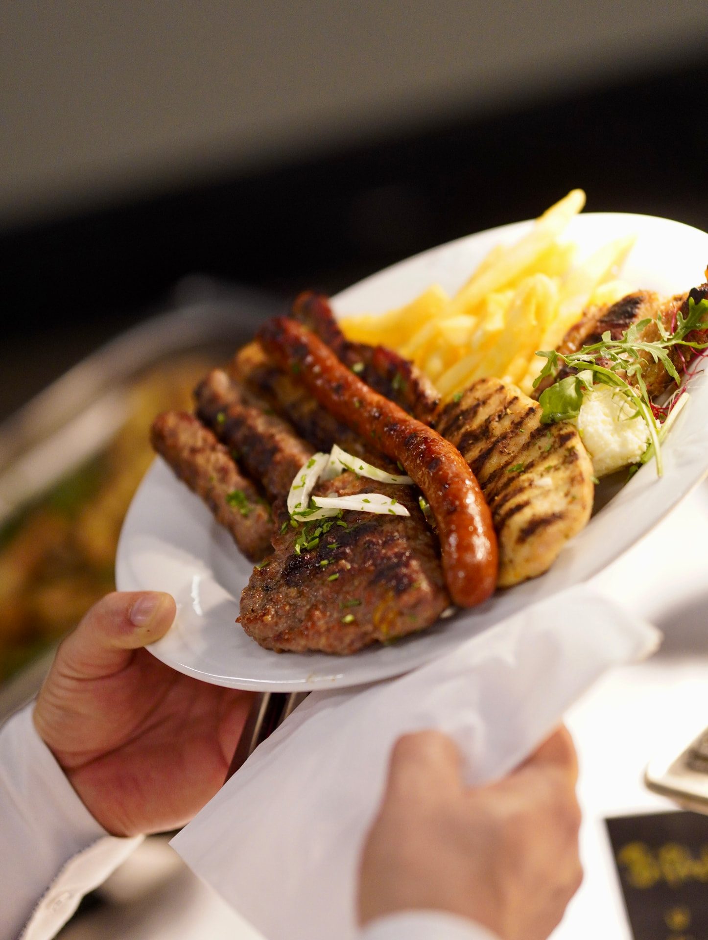 Grillteller mit Würstchen, Fleisch, Hähnchen, Pommes und Salat