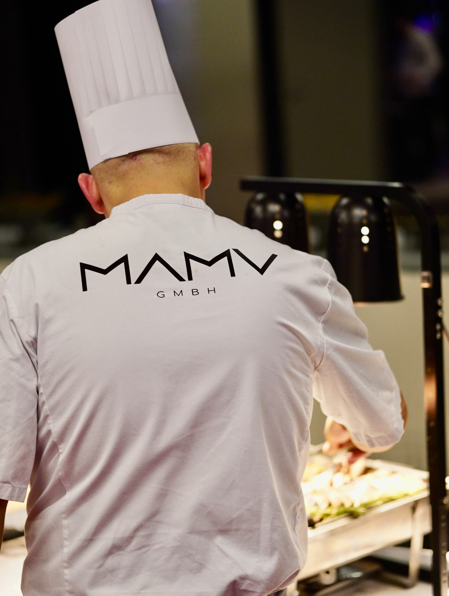 Küchenchef von Sallon 22 bei der Arbeit am warmen Cateringbuffet