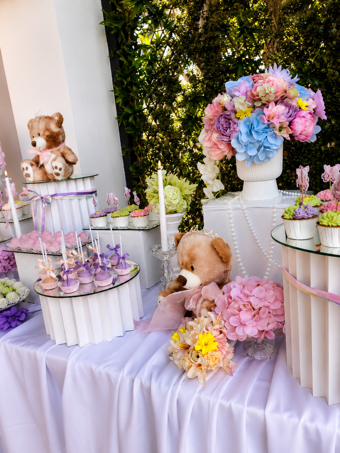 Pastelliger Desserttisch im Gartenstil mit Teddybären, Perlen und Cupcakes