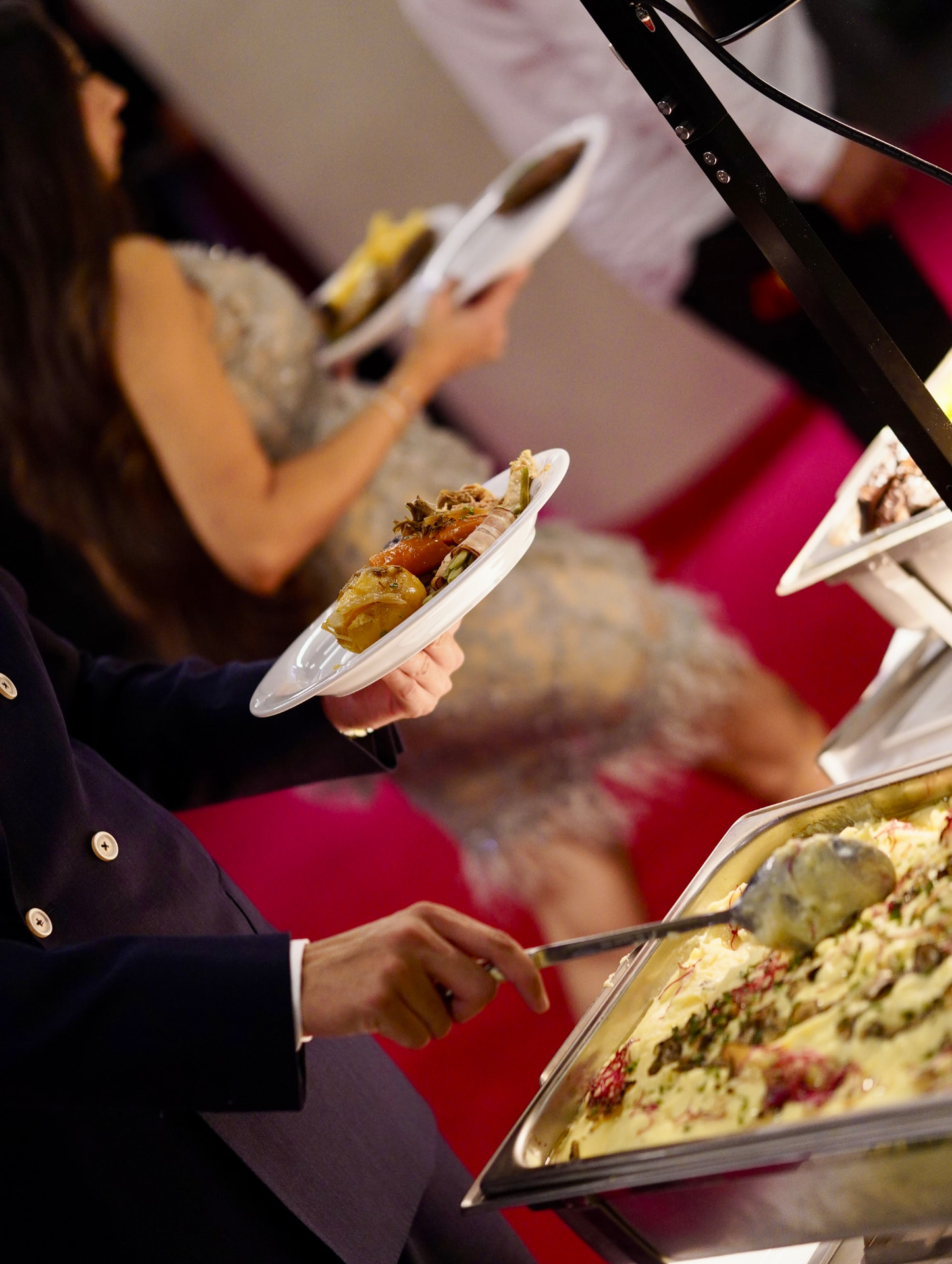 Gäste bedienen sich am warmen Buffet von Sallon 22