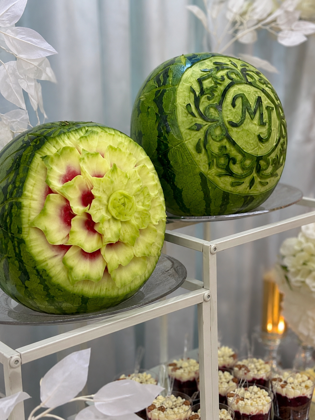 Kunstvoll geschnitzte Wassermelonen mit Blüten- und Monogramm-Motiv auf Etagere