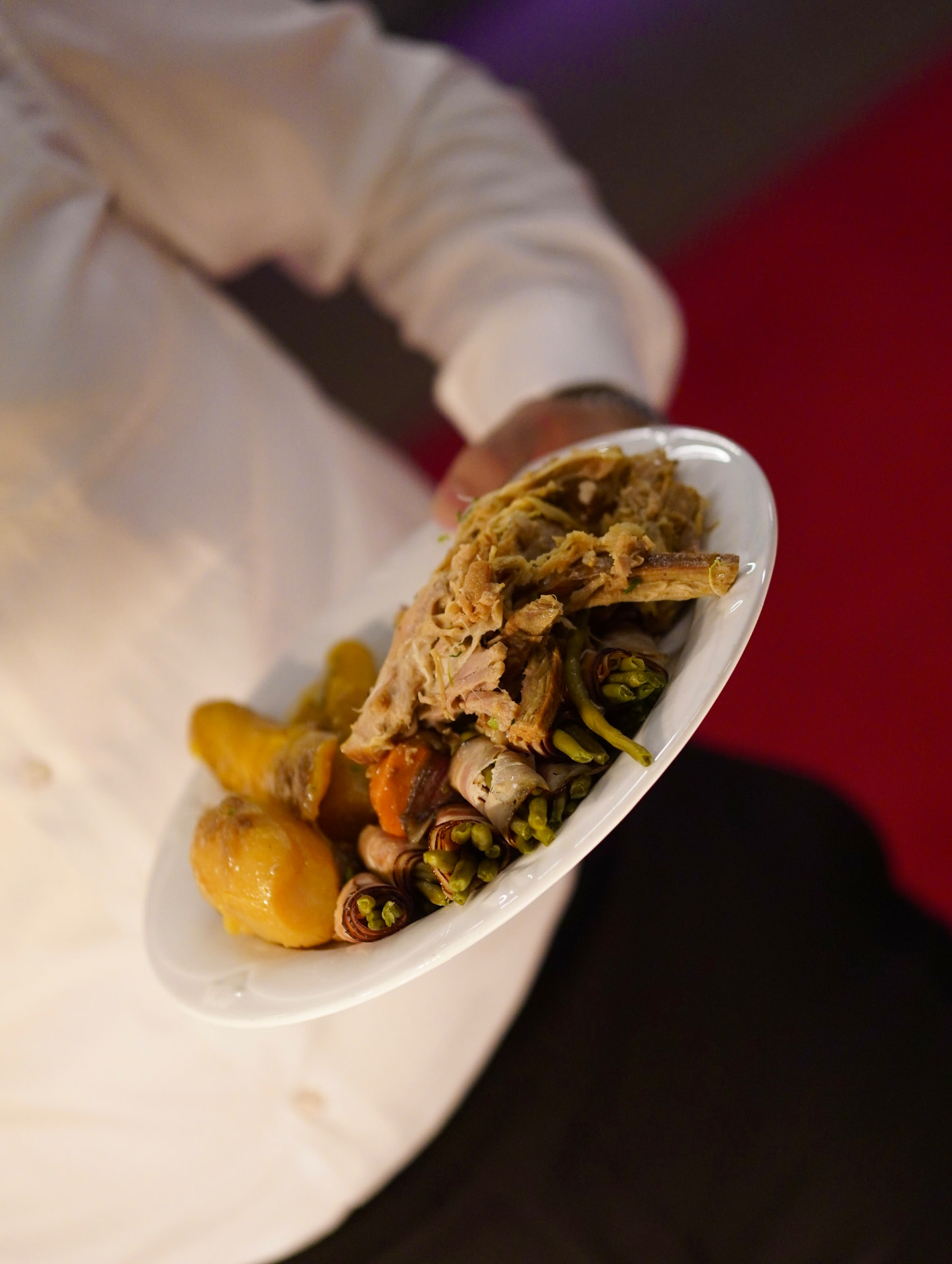 Catering-Teller mit Fleisch, Kartoffeln und Bohnen im Speckmantel
