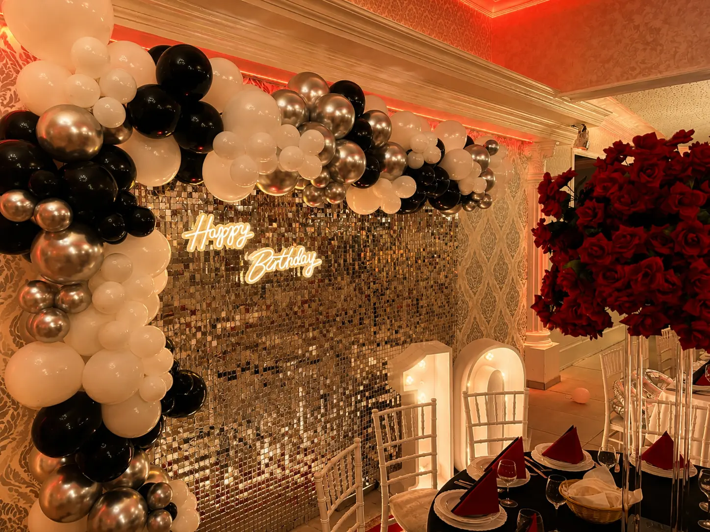 Geburtstagsdekoration mit schwarz-silberner Ballongirlande, Pailletten-Wand und Happy-Birthday-Leuchtschrift