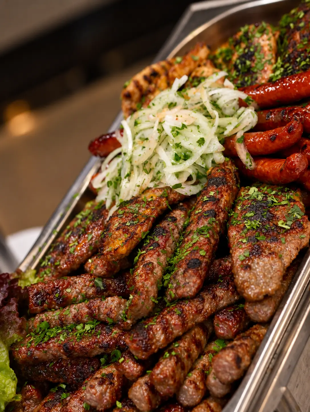 Gegrillte Fleischspezialitäten und Würstchen am warmen Buffet