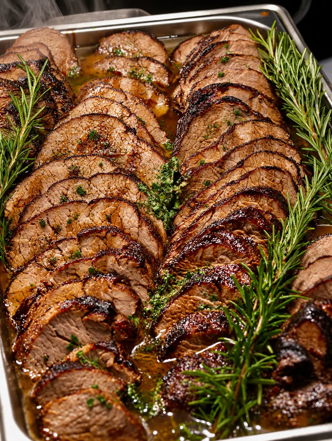Aufgeschnittener saftiger Braten mit Rosmarin am Buffet